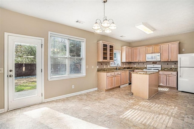 kitchen with a center island, decorative light fixtures, white appliances, light brown cabinetry, and sink