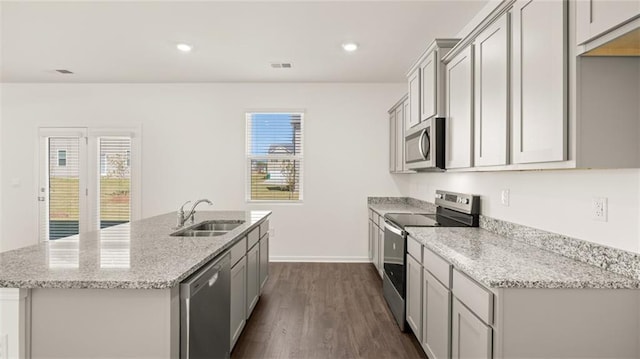605 Lobelia Way, Locust Grove, GA 30248 - kitchen featuring stainless steel appliances, a sink, a kitchen island with sink, dark wood-style flooring, and light stone countertops