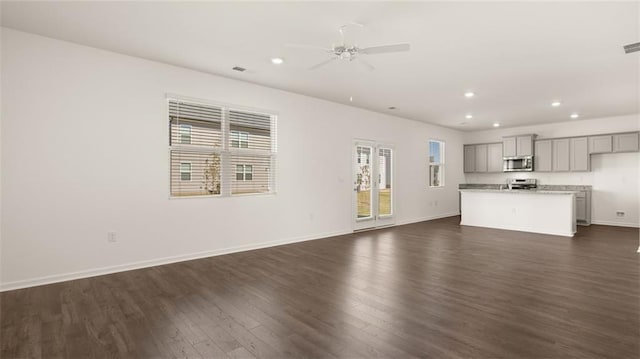 605 Lobelia Way, Locust Grove, GA 30248 - unfurnished living room featuring dark wood-style floors, recessed lighting, ceiling fan, and baseboards