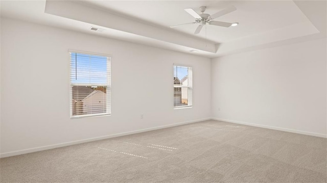 605 Lobelia Way, Locust Grove, GA 30248 - spare room featuring a tray ceiling, light colored carpet, baseboards, and a ceiling fan