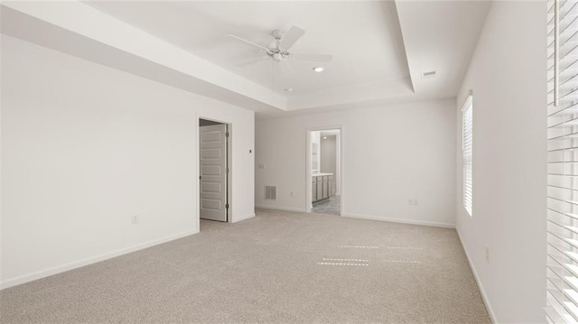 605 Lobelia Way, Locust Grove, GA 30248 - unfurnished bedroom with a raised ceiling, light colored carpet, baseboards, connected bathroom, and a ceiling fan