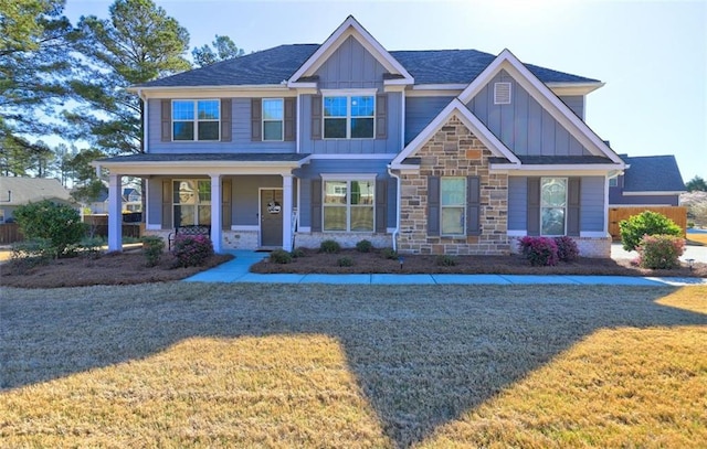craftsman-style home featuring board and batten siding, a front yard, and covered porch
