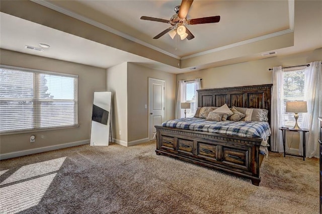 carpeted bedroom featuring a tray ceiling, baseboards, and crown molding
