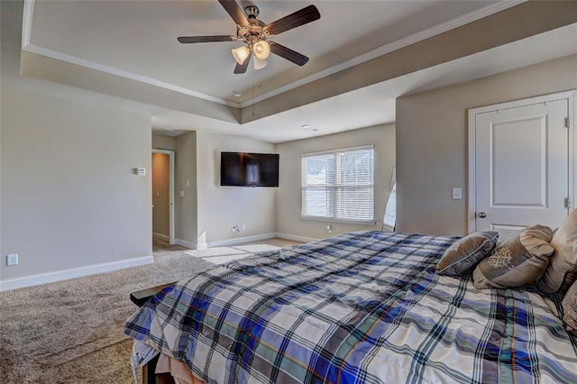 bedroom featuring carpet floors, baseboards, ornamental molding, and a raised ceiling