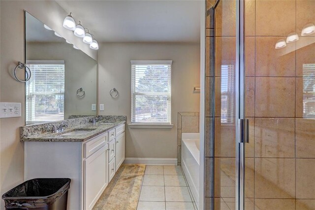 bathroom featuring a shower stall, double vanity, a sink, and tile patterned flooring