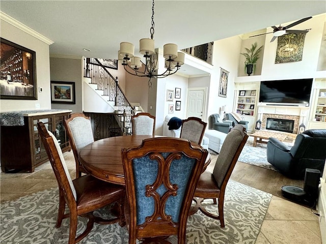 dining area with built in shelves, a glass covered fireplace, crown molding, and stairway