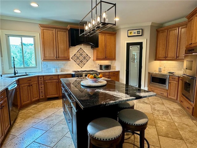 kitchen featuring brown cabinetry, a kitchen island, ornamental molding, stainless steel appliances, and a kitchen bar