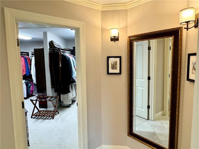 hallway with crown molding and light colored carpet