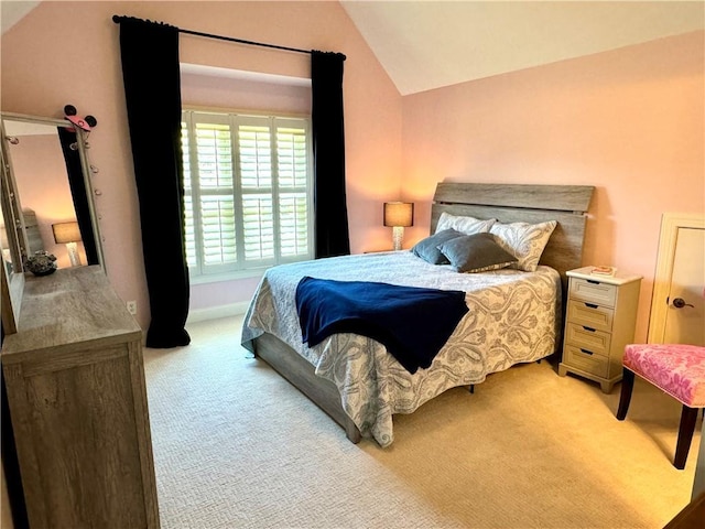 bedroom with lofted ceiling and light colored carpet