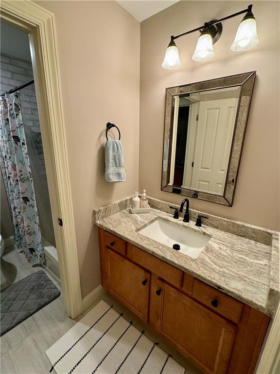 full bathroom featuring baseboards, vanity, toilet, and shower / bath combo with shower curtain