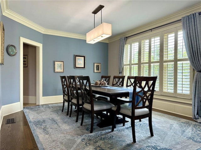 dining room with ornamental molding, dark wood-style flooring, and plenty of natural light