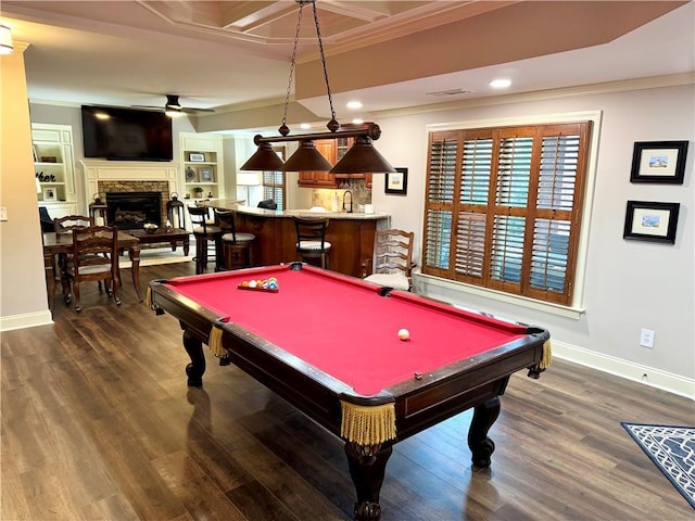 rec room with ornamental molding, dark wood-type flooring, baseboards, and a ceiling fan