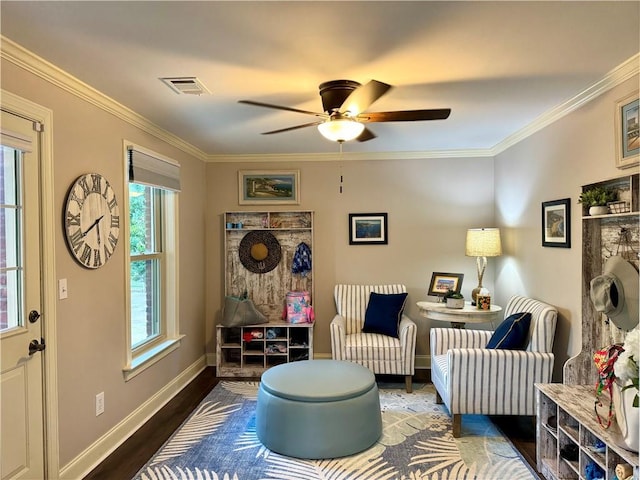 sitting room featuring crown molding, visible vents, baseboards, and dark wood-style flooring