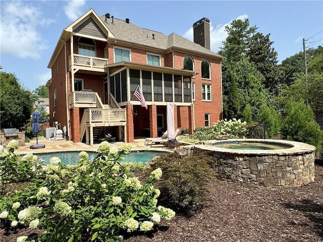 rear view of property featuring an outdoor hot tub, an outdoor pool, a sunroom, a chimney, and stairway