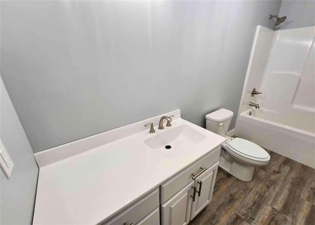 full bathroom with vanity, hardwood / wood-style flooring, shower / tub combination, and toilet