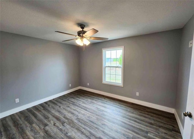 empty room with ceiling fan, dark wood-type flooring, and a textured ceiling