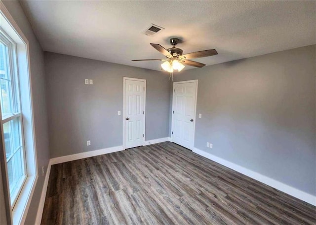 spare room featuring ceiling fan, dark hardwood / wood-style flooring, and a textured ceiling