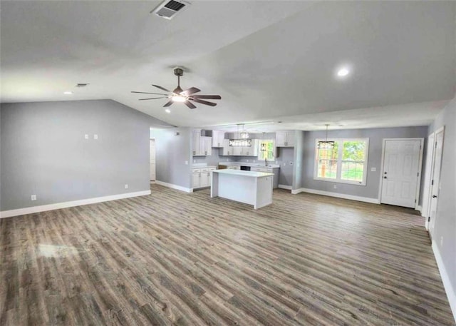 unfurnished living room featuring dark wood-type flooring, ceiling fan, and vaulted ceiling