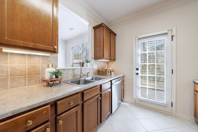 kitchen featuring visible vents, a sink, decorative backsplash, stainless steel dishwasher, and brown cabinets