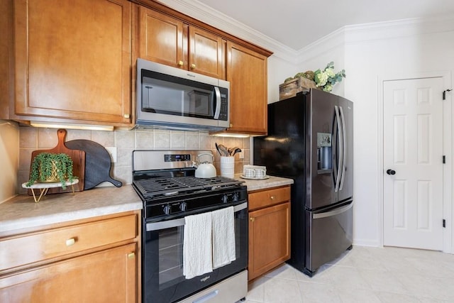 kitchen featuring tasteful backsplash, appliances with stainless steel finishes, brown cabinetry, crown molding, and light countertops