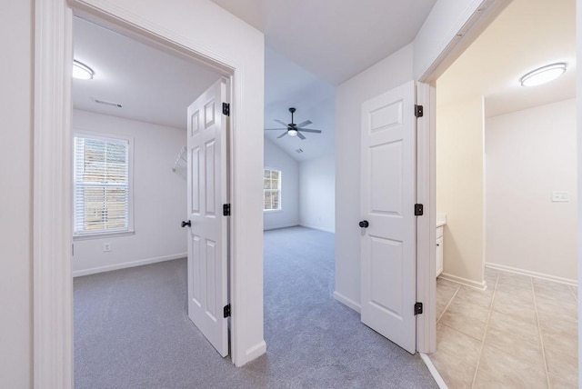 hallway with baseboards, plenty of natural light, and carpet flooring