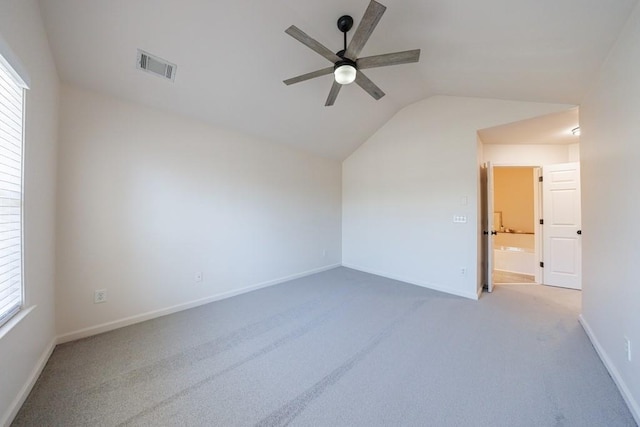 unfurnished room with visible vents, carpet, baseboards, ceiling fan, and vaulted ceiling