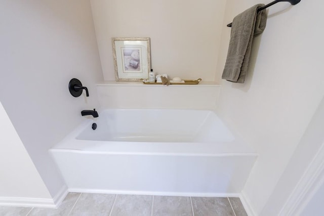 bathroom with a bath and baseboards