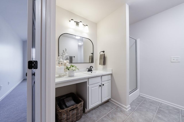 full bath featuring a shower with door, tile patterned floors, vanity, and baseboards