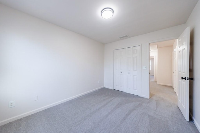 unfurnished bedroom featuring a closet, visible vents, carpet flooring, and baseboards