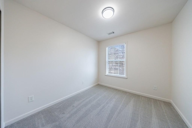 unfurnished room featuring carpet flooring, visible vents, and baseboards