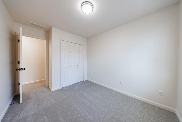 unfurnished bedroom with visible vents, baseboards, carpet, and a closet