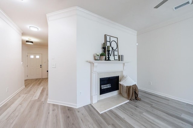 unfurnished living room featuring visible vents, a fireplace, crown molding, and wood finished floors