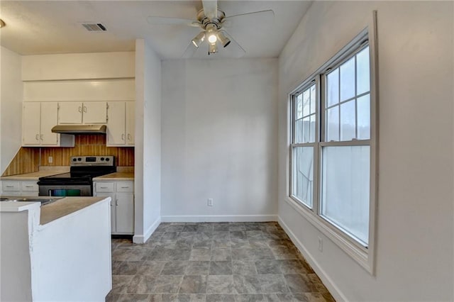 kitchen with under cabinet range hood, visible vents, white cabinets, light countertops, and stainless steel electric stove