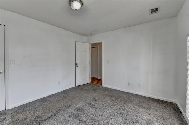 carpeted spare room featuring visible vents and baseboards