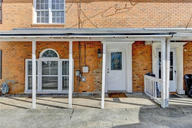 doorway to property with brick siding