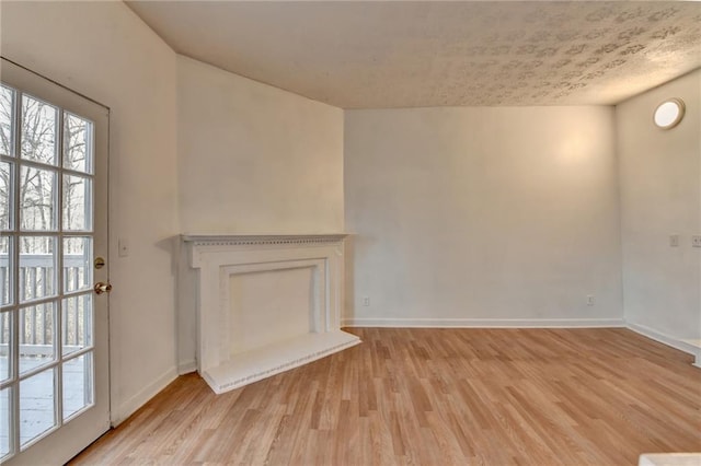 unfurnished living room featuring baseboards and light wood finished floors