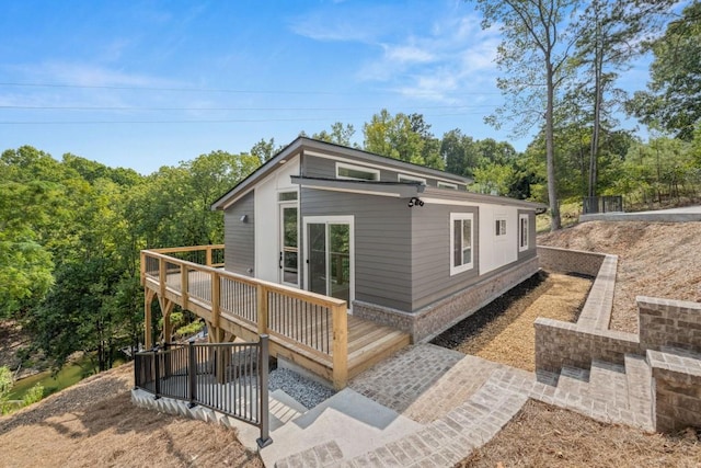 rear view of property featuring a wooden deck