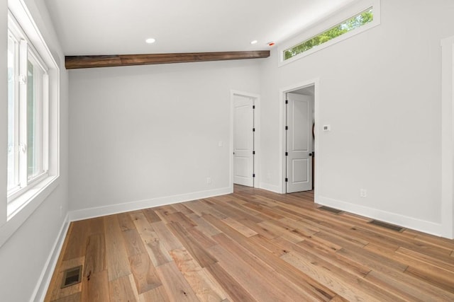 spare room featuring plenty of natural light, visible vents, light wood-style flooring, and baseboards