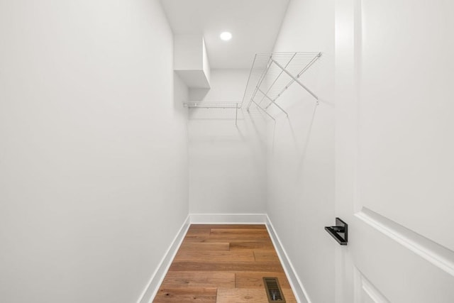 walk in closet with visible vents and wood finished floors