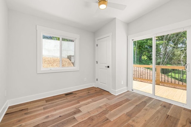 spare room featuring vaulted ceiling, ceiling fan, light wood-type flooring, and baseboards