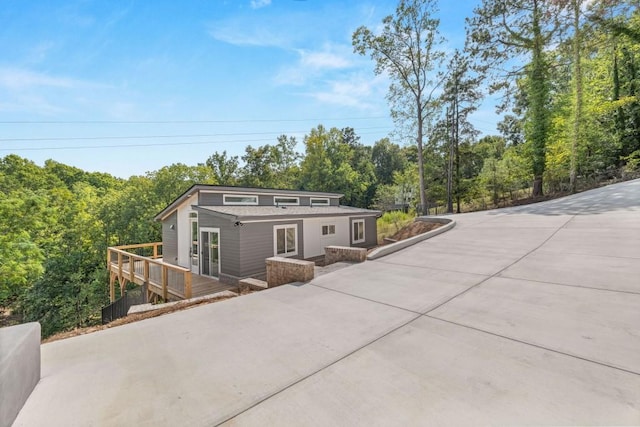 view of front of property featuring driveway and a wooden deck