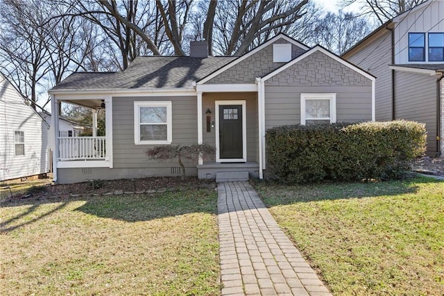 bungalow-style home featuring crawl space, a front lawn, a chimney, and a shingled roof