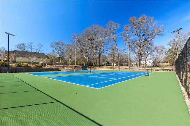 view of tennis court featuring fence