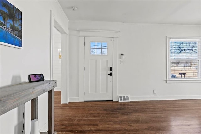 entrance foyer featuring baseboards, visible vents, wood finished floors, and ornamental molding