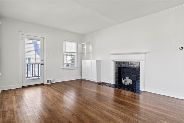 unfurnished living room featuring baseboards, a tiled fireplace, visible vents, and hardwood / wood-style floors