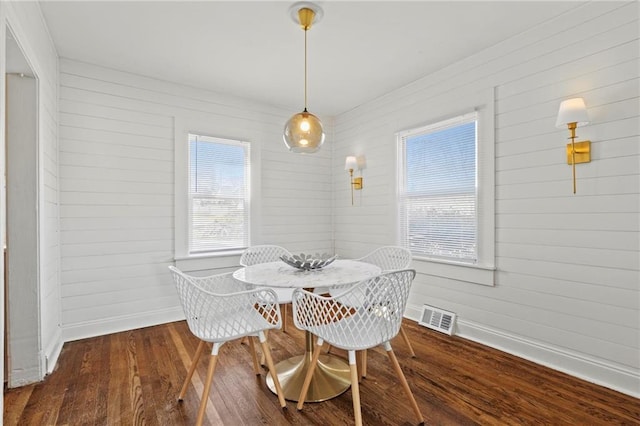 dining space featuring baseboards, visible vents, and wood finished floors