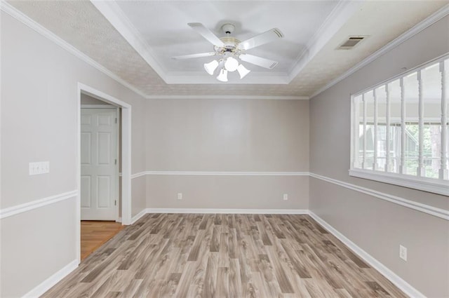 1980 Mcconnell Rd, Grayson, GA 30017 - spare room featuring a tray ceiling, light wood finished floors, ceiling fan, baseboards, and crown molding
