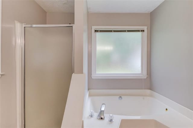 1980 Mcconnell Rd, Grayson, GA 30017 - full bathroom with a stall shower, a bath, and a textured ceiling