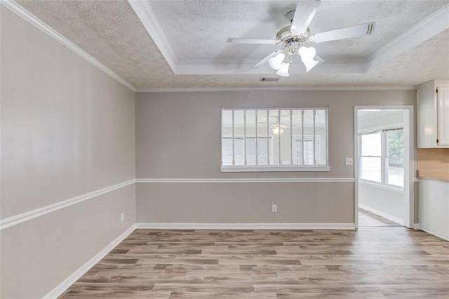 1980 Mcconnell Rd, Grayson, GA 30017 - unfurnished room with light wood finished floors, a textured ceiling, a tray ceiling, a ceiling fan, and crown molding