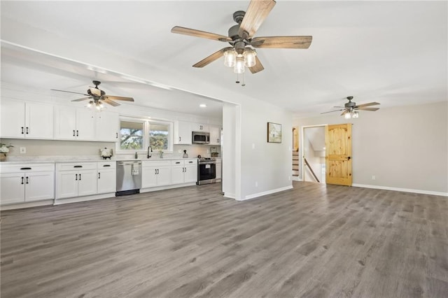 unfurnished living room featuring sink, hardwood / wood-style flooring, and ceiling fan